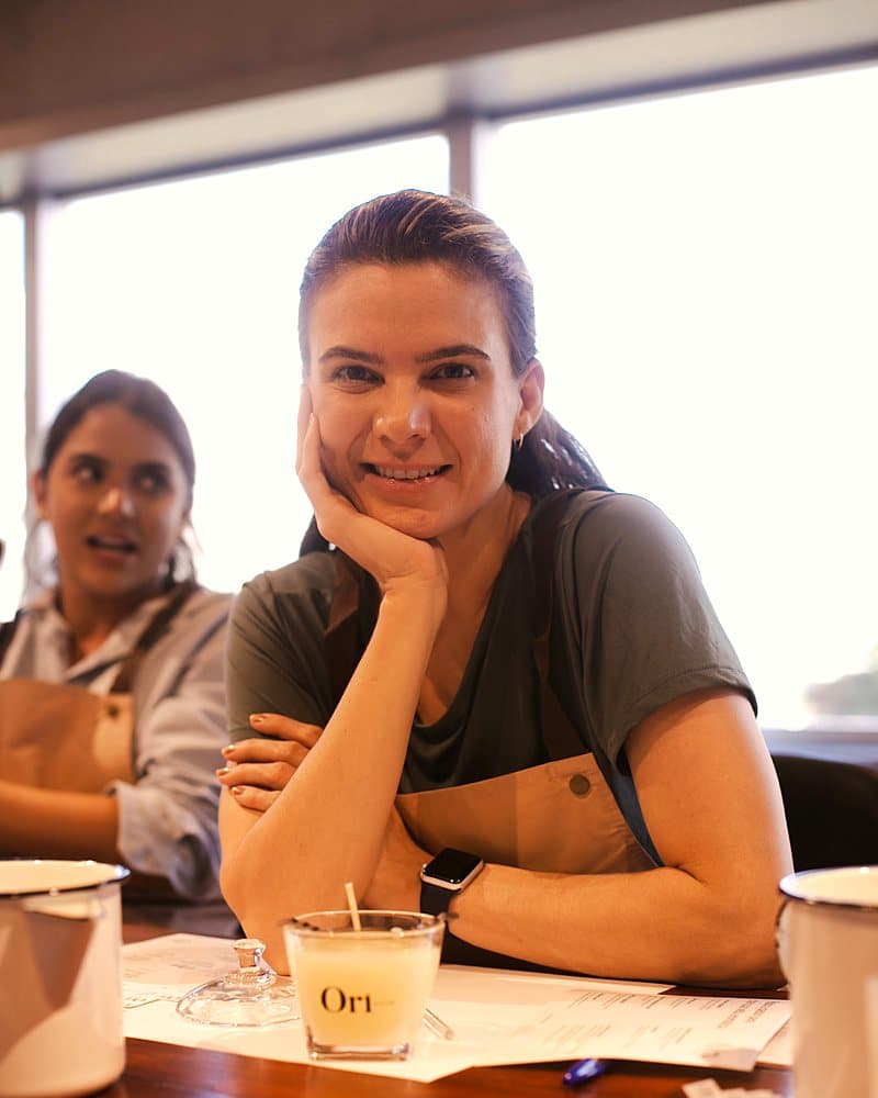 Participante sorrindo ao lado da vela recém-feita
